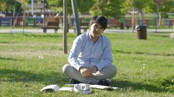 högskola studerande talande medan ser på kamera medan studerar i de parkera. video