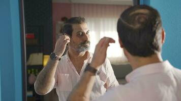 Beau homme regards à lui-même dans le miroir et admire il. video