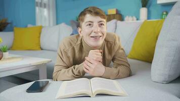 Young man at home daydreaming and laughing. video