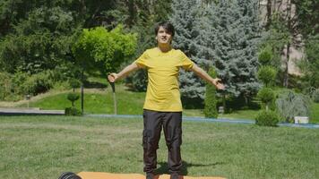 joven hombre hacer ejercicio en el parque haciendo cuerpo estiramientos con su brazos. video