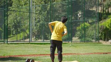 Young man doing sports, stretching waist left and right. video