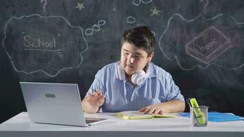 maschio alunno Lavorando fra carta e il computer portatile. video