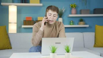 Young man arguing with his family on the phone gets angry and hangs up. video