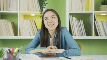 Portrait of happy Asian teenage schoolgirl reading a book. video