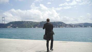 Businessman reaching his goal rejoicing by the sea. video