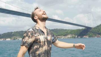 Happy young man walking happily by the sea. video