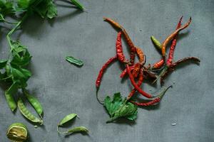 red chili with celery leaves on concrete floor photo