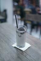 Chocolate milkshake with chocolate pieces and cake on top, cafe background atmosphere photo