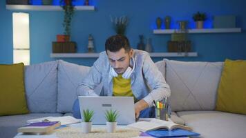 Man focusing on computer has serious expression. At home at night. video