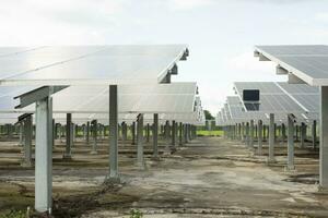 Engineer uses laptop computer to inspect solar panels, solar cell farm Concept of economic energy and cost saving photo