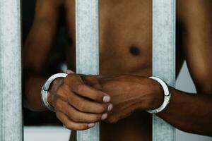 Prisoner handcuffed in a court of law and justice hearing. Handcuffs of the accused in prison Legal offenders are sentenced to prison. photo