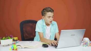 Negative expression of boy using laptop. video