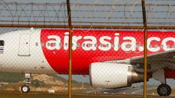 PHUKET, THAILAND FEBRUARY 16, 2023 - Aircraft Airbus A320, HSABN of AirAsia taxiing at Phuket Airport, side view. Asian lowcost airline. Passenger flight video