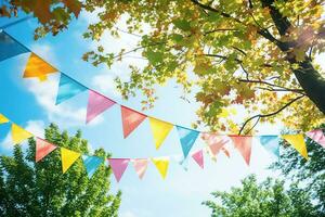 Colorful pennant  decoration in green  foliage on blue sky photo