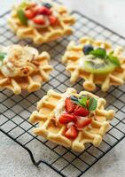 Freshly baked waffles with strawberries and blueberries photo