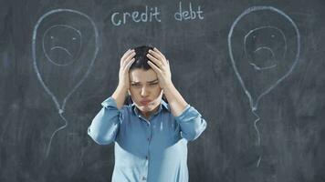 The woman writing Loan Debt looks on the blackboard with a sad expression. video