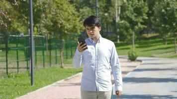 Outdoors young man arguing with the person he is talking to on the phone. video