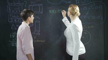 A teacher teaching subtraction to a girl student. video