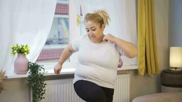 obesidade mulher fazendo perna exercícios dentro frente do a janela. video