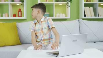 The boy is secretly using his father's laptop. Curious boy. video