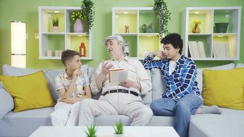 Grandpa telling stories to his grandchildren. He is reading a book. video