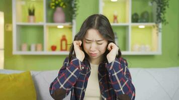 asiatico giovane donna graffiare sua orecchie. video