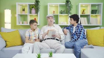 Children listening attentively to their grandfather reading a book. video