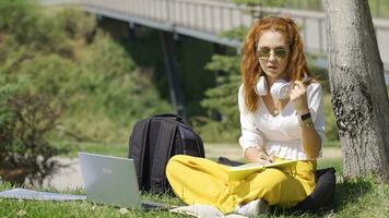 University student studying in the park solving questions. video