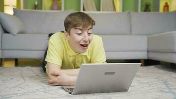 Young man looking at laptop at home says wow, amazed. video