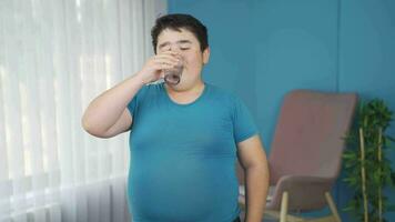 Obesity boy drinks diet juice looking at camera. video