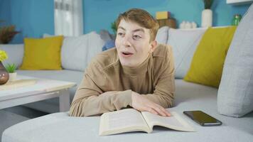 Young man admiring the book. He is surprised by what he reads. video