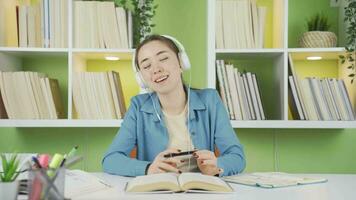 Asian teenage schoolgirl listening to cheerful and lively music. video