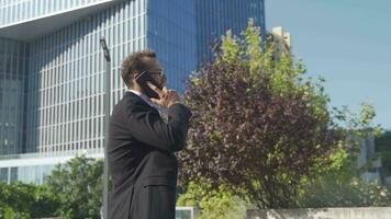 Business man walking while talking on the phone. video