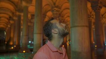 Tourist looking at columns in indoor historical place. video