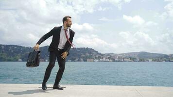 Businessman dancing happily by the sea. video