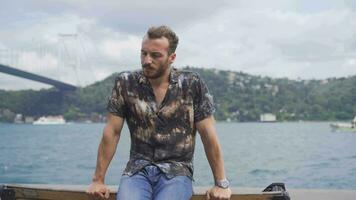 Angry young man against the strait in the sea. video