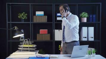 Businessman talking on the phone standing in the office. video