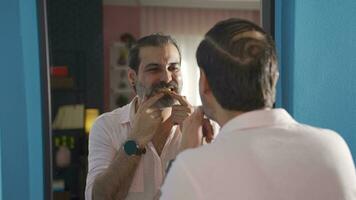 Man looking in the mirror looking at his teeth. video