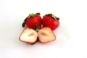 Whole and sliced piece strawberry fruit isolated on white paper background. photo