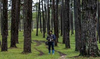 Photographer is taking photo of the new discovering bird species while exploring in the pine forest for surveying and locating the rare biological diversity and ecologist on field study usage