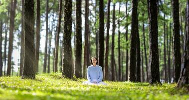 mujer relajantemente practicando meditación en el pino bosque a alcanzar felicidad desde interior paz sabiduría con haz de Dom ligero para sano mente y alma concepto para sano mente y alma foto
