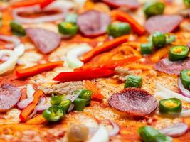 pizza with meat, mushrooms, tomatoes, cheese and peppers on white plate photo