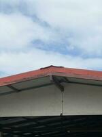 roof of an industrial building with red roof and blue sky. photo