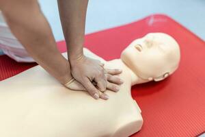 CPR class with instructors talking and demonstrating firt aid, compressions ans reanimation procedure. Cpr dummy photo