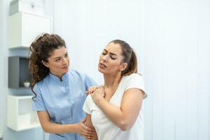 mujer médico osteópata en médico uniforme fijación mujer pacientes hombro y espalda articulaciones en manual terapia clínica durante visita. profesional osteópata durante trabajo con paciente concepto foto