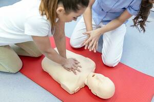 Demonstrating CPR  Cardiopulmonary resuscitation  training medical procedure on CPR doll in the class.Doctor and nurse students are learning how to rescue the patient.First aid for safe life concept. photo