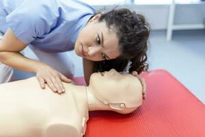 mujer practicando cpr técnica en tonto durante primero ayuda capacitación. primero ayuda formación - cardiopulmonar resucitación. primero ayuda curso en cpr ficticio. foto