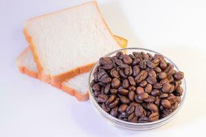 coffee beans and slice of bread isolated on the white background. photo