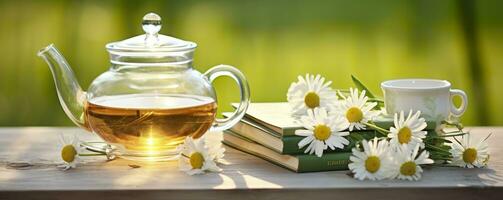 Chamomile flowers, books, a glass teapot, and a cup of herbal tea on a table closeup. Generative AI photo