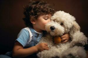 Cute little boy with curly hair is hugging a dog, studio shot photo